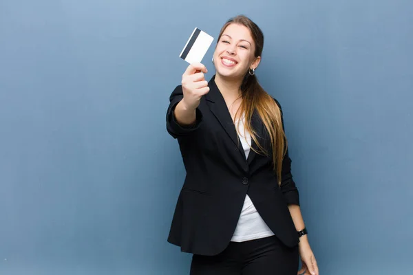 Mujer Rubia Joven Con Una Tarjeta Crédito Contra Fondo Pared —  Fotos de Stock