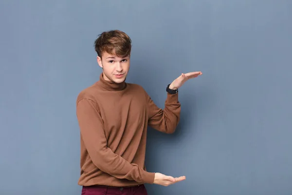 Junger Blonder Mann Der Einen Gegenstand Mit Beiden Händen Auf — Stockfoto