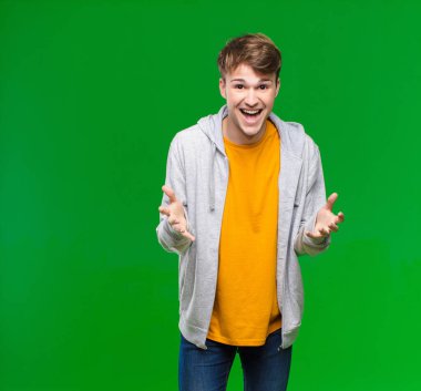 Genç sarışın adam kendini mutlu, şaşkın, şanslı ve şaşırmış hissediyor. Krom tuş duvarına karşı inanılmaz