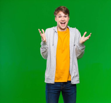 Genç sarışın adam, ağzı açık ve şaşırmış, şok olmuş ve şaşırmış. Krom anahtar duvarına karşı inanılmaz bir sürpriz.