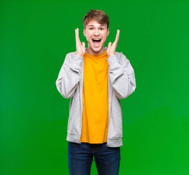 Genç sarışın adam şok olmuş ve heyecanlı, gülüyor, şaşırmış ve mutlu çünkü kroma anahtarına karşı beklenmedik bir sürpriz var.