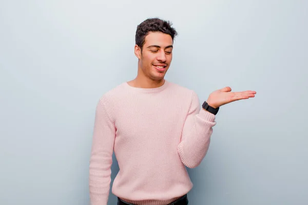 Joven Árabe Sintiéndose Feliz Sonriendo Casualmente Mirando Objeto Concepto Sostenido —  Fotos de Stock