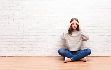 Genç sarışın güzel kız stresli ve hayal kırıklığına uğramış görünüyor. Baskı altında çalışıyor. Baş ağrısı ve yerde oturan sorunlarla uğraşıyor.
