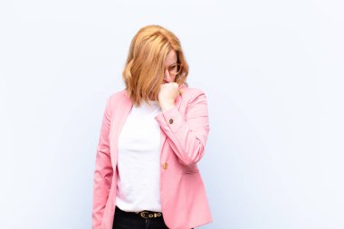 Orta yaşlı kadın ciddi, düşünceli ve endişeli, elleri çenesine bastırılmış bir şekilde yan bakıyor.