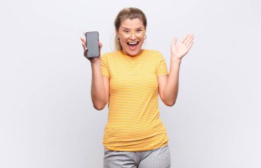 Genç, güzel Latin bir kadın mutlu, heyecanlı, şaşırmış ya da şok olmuş hissediyor, gülümsüyor ve şaşırıyor.