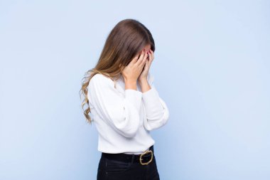 Genç, güzel, İspanyol bir kadın, üzgün, hayal kırıklığına uğramış bakışlarıyla gözlerini kapatıyor. Ağlıyor, mavi duvara bakıyor.