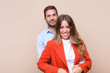 Genç ve güzel bir çift bej düz duvara karşı