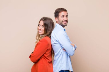 Genç ve güzel bir çift bej düz duvara karşı