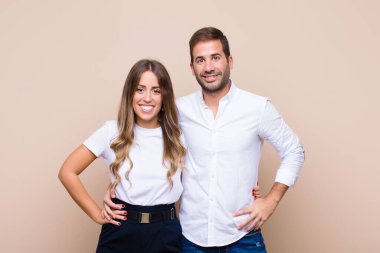 Genç ve güzel bir çift bej düz duvara karşı