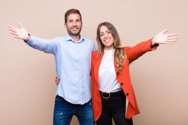 Genç ve güzel bir çift bej düz duvara karşı