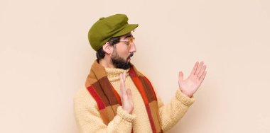 Genç havalı sakallı adam şok olmuş ve hayrete düşmüş görünüyor, inanılmaz bir şey fark ettiğinde şaşkınlık içinde.