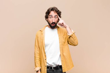 Genç çılgın adam şaşırmış, ağzı açık, şok olmuş, düz duvara karşı yeni bir düşünce, fikir ya da konsept fark ediyor.