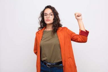 Genç, güzel bir kadın kendini ciddi, güçlü ve asi hissediyor. Yumruğunu kaldırıyor, protesto ediyor ya da beyaz duvara karşı devrim için savaşıyor.