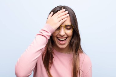 Genç ve güzel bir kadın gülüyor ve alnına şaplak atıyor. Unutmuşum yoksa mavi duvara karşı yaptığım aptalca bir hataydı. 