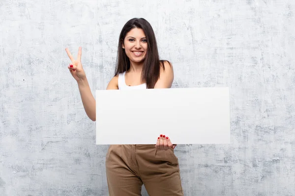 Junge Hübsche Frau Hält Ein Banner Gegen Grunge Wand — Stockfoto