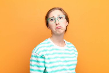 Genç sarışın kadın üzgün ve mızmızlanıyor, mutsuz bir bakışla, negatif ve hayal kırıklığına uğramış bir tavırla ağlıyor.