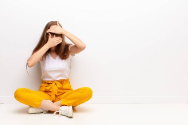 Genç sarışın kadın kameraya hayır diyen iki eliyle yüzünü kapatıyor! Fotoğrafları reddetmek ya da yerde oturmayı yasaklamak