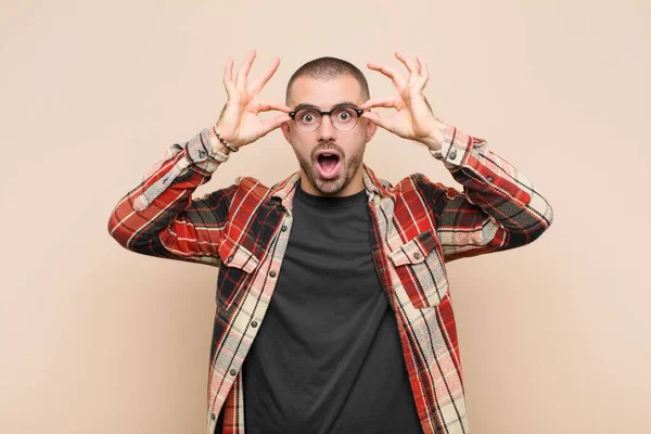 Jovem Homem Bonito Sentindo Chocado Surpreso Surpreso Segurando Óculos Com — Fotografia de Stock