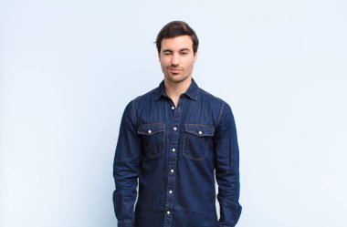 Adam mutlu ve arkadaş canlısı görünüyor, gülümsüyor ve sana olumlu bir tavırla göz kırpıyor.