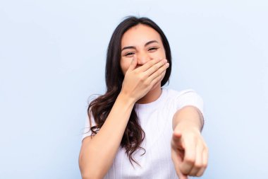 Duvara yaslanmış genç Latin güzel kadın.