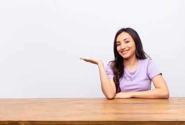 Genç Latin güzel kadın neşeyle gülümsüyor, mutlu hissediyor ve fotokopi odasında bir konsept gösteriyor.