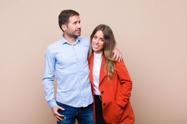 Genç ve güzel bir çift bej düz duvara karşı