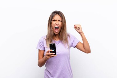 Genç ve güzel bir kadın sinirli bir ifadeyle ya da yumruklarıyla bağırıyor. Akıllı bir telefonu tutarak başarıyı kutluyor.