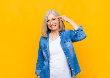 Yaşlı ya da orta yaşlı güzel bir kadın kafası karışık ve şaşkın hissediyor. Deli, deli ya da aklını kaçırmış olduğunu gösteriyor.