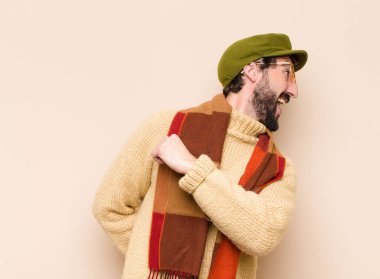 Genç havalı sakallı adam mutlu, pozitif ve başarılı hissediyor, meydan okumayla karşılaştığında motive oluyor ya da iyi sonuçları kutluyor.