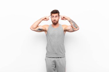 Genç yakışıklı bir adam kafası karışık ya da şüpheci, bir fikre odaklanmış, çok düşünüyor, uzayı kopyalamak istiyor. spor konsepti