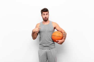 Kafası karışmış, kafası karışmış ve kendine güveni olmayan genç yakışıklı bir adam kendini gösterip kim olduğumu soruyor, ben mi? Basketbol topu tutuyor..