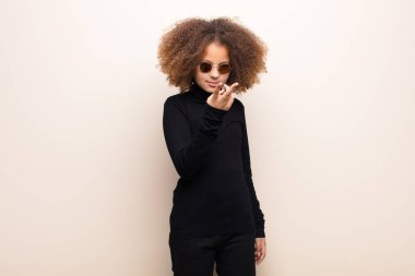 Afrikalı Amerikalı küçük kız düz duvara yaslanmış. cool konsept