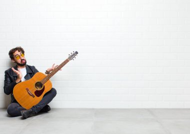 Odada gitarlı genç yakışıklı bir adam.