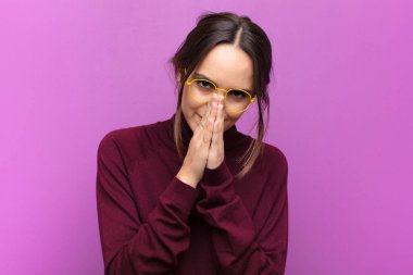 Genç, güzel bir kadın endişeli, umutlu ve dindar. Avuçlarını sıkarak dua ediyor, mor duvara karşı af diliyor.