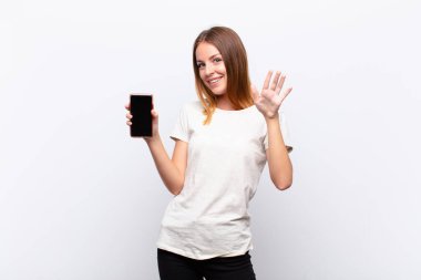 Kızıl saçlı güzel kadın mutlu ve neşeli bir şekilde gülümsüyor, el sallıyor, seni selamlıyor, ya da elinde akıllı bir telefonla veda ediyor.