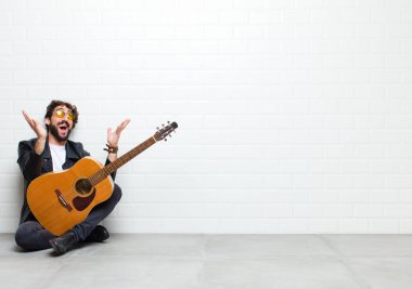 Gitarlı genç adam yerde.