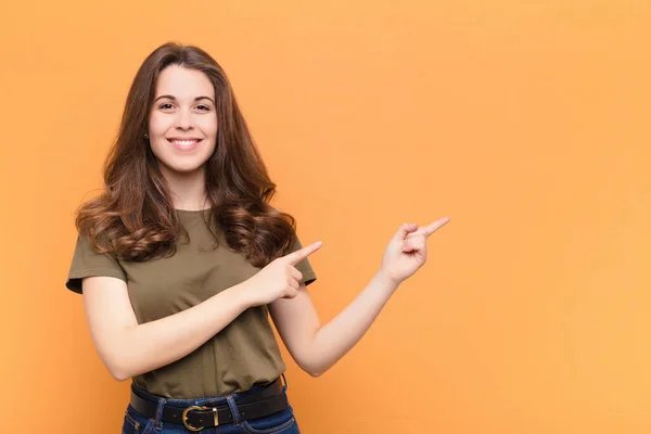 여자가 행복하게 미소짓고 손으로 주황색 물체를 복사하는 공간에서 물체를 주면서 — 스톡 사진