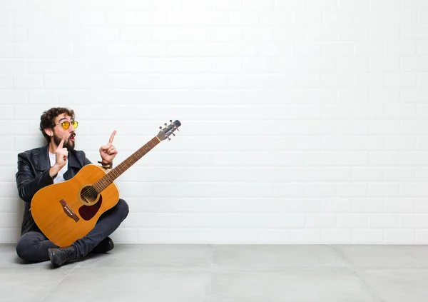 Jonge Man Spelen Gitaar Baksteen Muur Achtergrond — Stockfoto