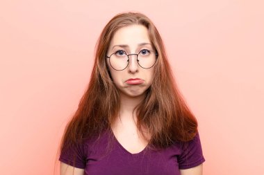 Genç sarışın kadın üzgün ve mızmızlanıyor, mutsuz bir bakışla, negatif ve hayal kırıklığına uğramış bir tavırla ağlıyor.