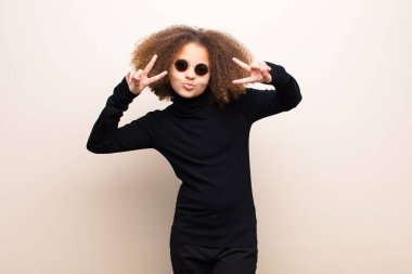 Afrikalı Amerikalı küçük kız düz duvara yaslanmış. cool konsept