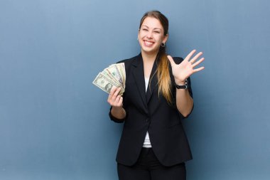 Dolar banknotları ile genç sarışın kadın grunge duvar arka planında