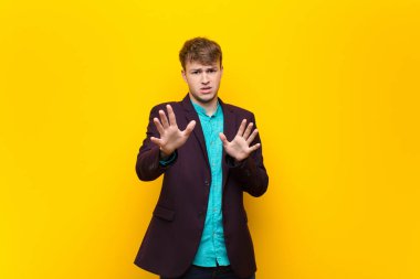 Dehşete kapılmış genç sarışın bir adam korku ve panik içinde geri çekilip çığlık atıyor. Duvara yaslanmış bir kabusa tepki veriyor.