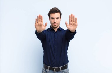 Adam ciddi görünüyor, mutsuz, kızgın ve hoşnutsuz giriş ya da her iki avuçta da dur diyor.