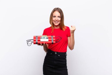 Kızıl saçlı, güzel bir kadın öfkeli bir ifadeyle bağırıyor ya da yumruklarıyla başarıyı dinamit bombasıyla kutluyor.