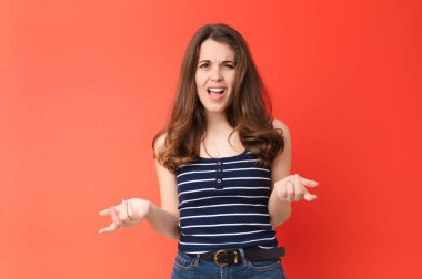 Genç, güzel bir kadın kendini cahil ve kafası karışık hissediyor. Hangi seçeneği seçeceğinden emin değil. Kırmızı duvara karşı merak içinde.