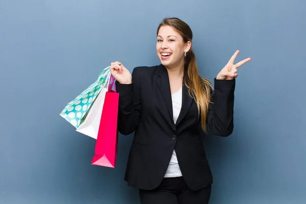 Jovem Mulher Loira Com Sacos Compras Contra Fundo Parede Grunge — Fotografia de Stock