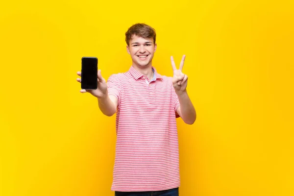 一个拿着智能手机的金发年轻人 — 图库照片