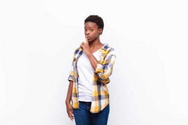 Genç ve güzel siyahi kadın sessizlik ve sessizlik istiyor, parmaklarıyla ağzının önünde işaret ediyor, 