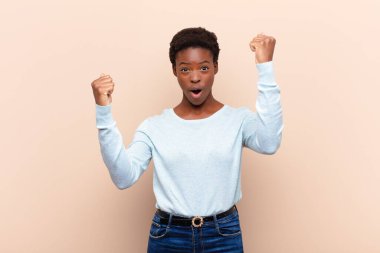 Genç ve güzel siyahi kadın inanılmaz bir başarıyı kutluyor. Kazanan gibi, heyecanlı ve mutlu görünüyor. Al bunu.!