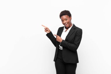 Genç, güzel, siyah bir kadın. Neşeli ve şaşırmış. Şok olmuş bir ifadeyle gülümsüyor.